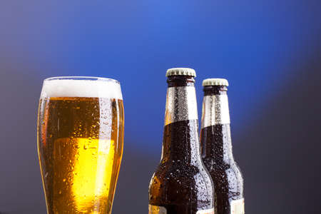 Close up of glass of light beer and two beer bottlesの写真素材