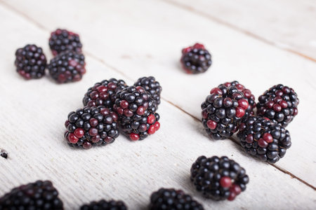 Close up of delicious blackberry on white  wooden table