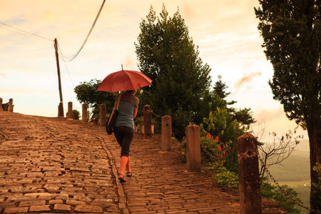 MOTOVUN, CROATIA - JULY, 12: Woman with umbrella walking on typical stone street of the town on July 12, 2017のeditorial素材