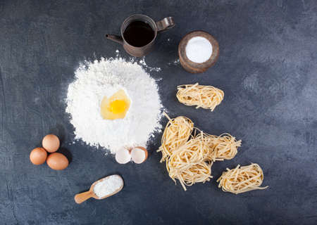 Italian homemade pasta called fettuccine next to flour and eggsの写真素材