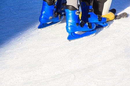 People skating with blue skates on the ice area 