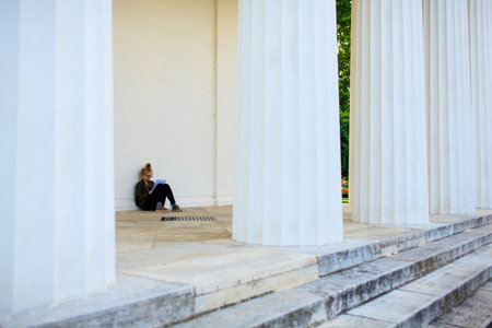VIENNA, AUSTRIA - MAY, 22: Nice girl reading a book next to the columns of the Theseus Temple on May...