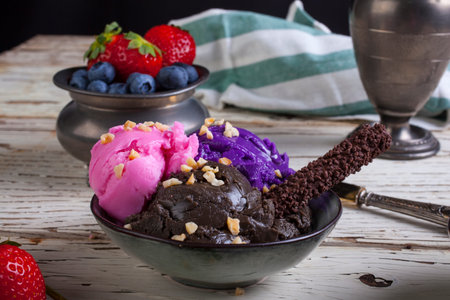Variety of ice cream scoops in the bowls. Chocolate, strawberry and blueberry flavours
