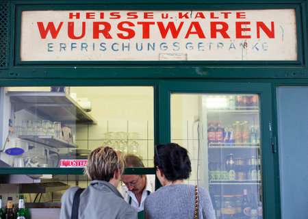 VIENNA, AUSTRIA - MAY, 22: A couple of friend waiting a hot dog in typical viennese fast food snack bar called Wurstwaren on May 22, 2018のeditorial素材