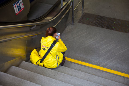 VIENNA, AUSTRIA - MAY, 22: Girl sitting in the subway staircase using a mobile phone on May 22, 2018のeditorial素材