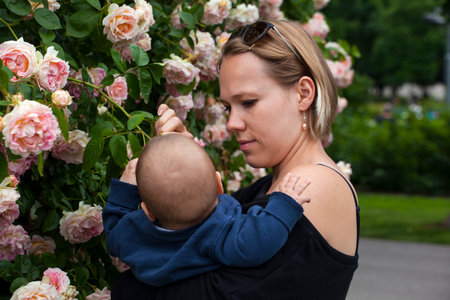 VIENNA, AUSTRIA - MAY, 22: Mother embracing er cute little son next to a roses hedge on May 22, 2018のeditorial素材