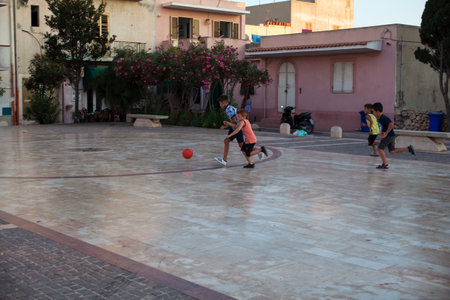 LAMPEDUSA, ITALY - AUGUST, 03: Children play soccer in the Lampedusa square on August 03, 2018のeditorial素材