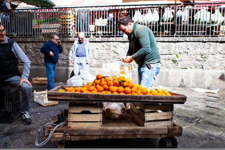 CATANIA, ITALY - APRIL, 26: Salesman next to his fruit stall in the street fish market on April 26, 2019のeditorial素材