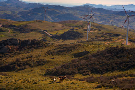 View of windmills in the Sicilian countryside. Etna volcano in the backgroundの写真素材
