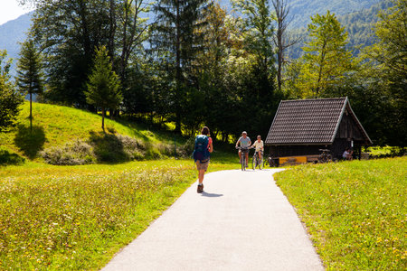 BOHINJ, SLOVENIA - AUGUST, 04: Young woman with backpack hiking along the path in the Slovenian countryside on August 04, 2019のeditorial素材