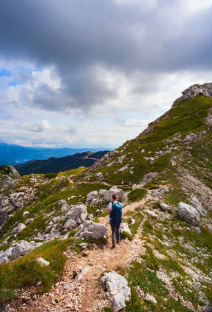 Young woman with backpack hiking along the path in the scenic Vogel mountain part of southern Julian Alps and Triglav National Park heritage of Sloveniaの写真素材