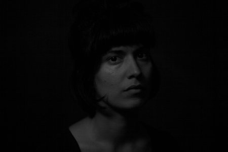 Dramatic portrait of an indian girl on black background