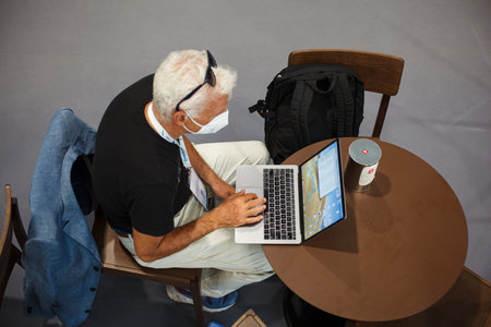 Trieste, Italy - September, 06: Top view of a man sitting at table working with his notebook in the...