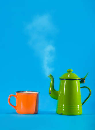 Vintage teacup and orange cup on blue background. Copy space on topの写真素材