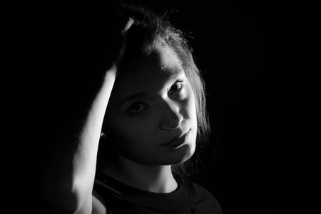 Black and white portrait of an Italian young woman on black background