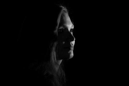 Black and white portrait of an Italian young woman on black background