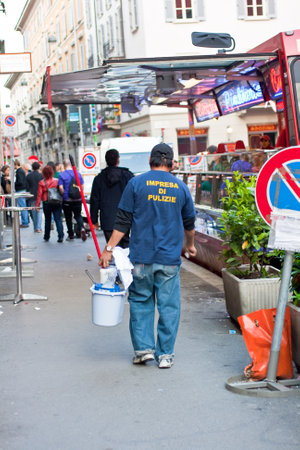 Milan, italy - April, 24: Professional cleaner walking on the street holding bucket with cleaning supplies on April 24, 2009のeditorial素材