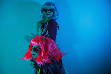 Little girls wearing a colorful wig and heart-shaped sunglasses posed for a photo shooting on the...