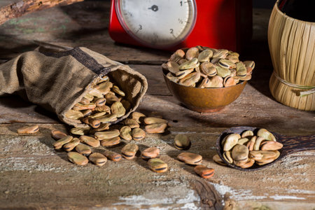 Composition with dried broad beans, whine and weight scale in a wooden table