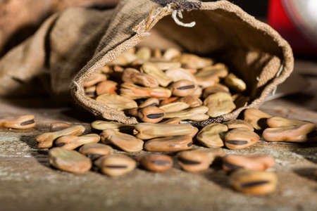 Close up of dried broad beans, and weight scale in a wooden tableの写真素材