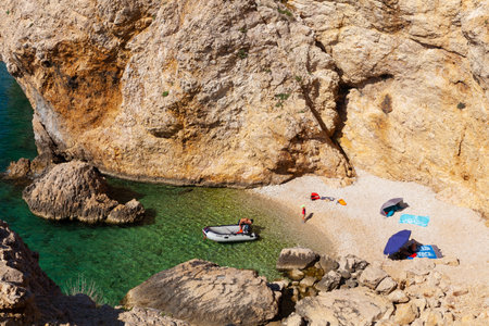 Stara Baska, Croatia - July, 22: Family relaxing in the Stara Baska beach during the summer season on July 22, 2020のeditorial素材