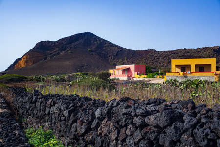 Characteristic view of Linosa with the typical colorful houses and the dry stone wall built with lava stonesの写真素材