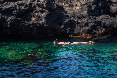 Woman Snorkeling in the blue water of Linosa sea, Linosaの写真素材