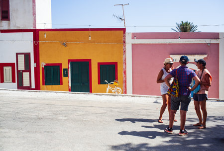 Linosa, Italy - July, 27: A group of tourists in the street of Linosa with the typical houses on the background on July 27, 2021のeditorial素材