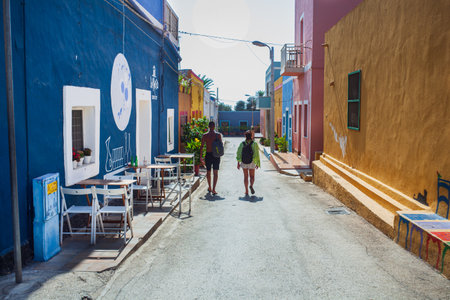 Linosa, Italy - July, 27: A couple of tourists in the street of Linosa with the typical colorful houses on July 27, 2021のeditorial素材