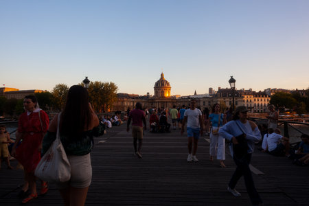 Paris, France - July, 14: People walking in the Pont des Arts Artists bridge of Paris with the Institut de France in the background on July 14, 2022のeditorial素材