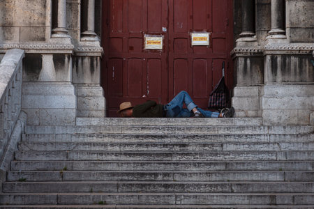 Man laying on the steps of the Sacred heart Basilica in Paris, Franceの写真素材