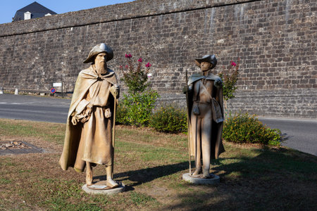 Pilgrims statue near the fortified medieval walls of the French town Navarrenx. Classified as one of the most beautiful villages in France and first bastioned city. It is also an important stop for pilgrims on the Chemin du Puy, way to Santiago de Compostのeditorial素材