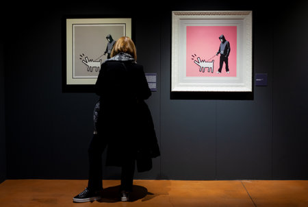 Trieste, Italy - January 21, 2023: Woman looking the Screen prints titled Choose your weapon by Banksy. Exposition titled The Great Communicator Banksy, Hall of Enchantments. Courtesy Deodato Galleryのeditorial素材