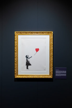 Trieste, Italy - January 21, 2023: Screen print titled Girl with Balloon by Banksy. The Great...