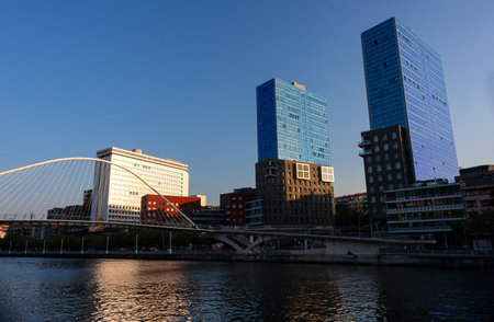 Bilbao, Spain - August 02, 2022: Nervion River and the Zubizuri bridge. View of the Bilbao riverside at sunsetのeditorial素材