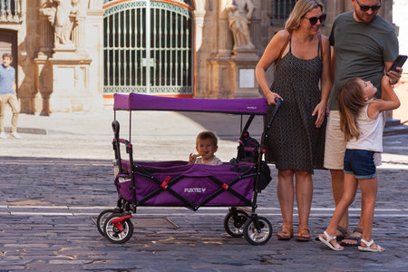 Pamplona, Spain - July, 31: Big family father, mother, daughter and baby in stroller in the city...