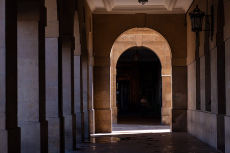 Pamplona, Spain - July, 31: People walking in the Arched colonnade by the historic Plaza del...