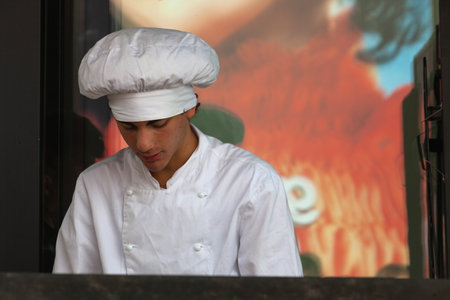 Trieste, Italy - October 8, 2023: Italian male chef in white uniform cooking during the event of Barcolana 55のeditorial素材