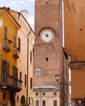 A view of the municipal tower with its clock in the historic center of Mantua, Italy, framed by the city's charming cobblestone streets, Italyの写真素材