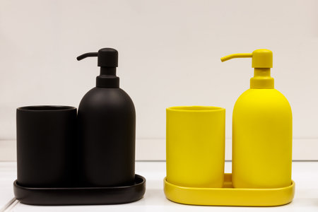 A set of blue and yellow liquid soap dispensers placed on a bathroom shelf, adding a touch of color and style to the space.の写真素材