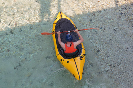 River Kayaker Aerial View. Caucasian Sportsman in the yellow Kayak Paddling on the Scenic Soca river, Bovec, Sloveniaの写真素材