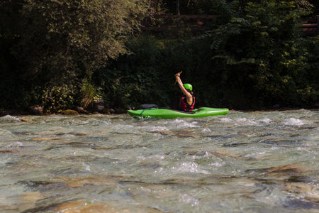 Water Sports Enthusiast Young Woman Kayaking celebrates winning at canoe regatta, Soca river, Bovec, Sloveniaの写真素材