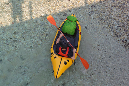 River Kayaker Aerial View. Caucasian Sportsman in the yellow Kayak Paddling on the Scenic Soca river, Bovec, Sloveniaの写真素材