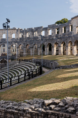 Ancient heritage in Pula, Istria, Croatia. Arches of monumental ancient Roman arena. Detail of historic amphitheater, wide angle view of high walls on blue sky background.の写真素材