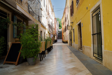View of the sunny colorful stone street of ancient Pula town, Croatiaの写真素材