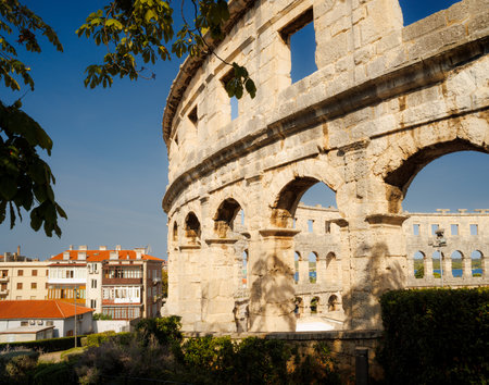 Ancient heritage in Pula, Istria, Croatia. Arches of monumental ancient Roman arena. Detail of historic amphitheater, wide angle view of high walls on blue sky background.の写真素材
