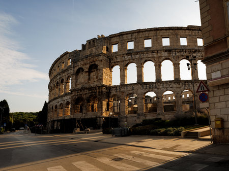 Ancient heritage in Pula, Istria, Croatia. Arches of monumental ancient Roman arena. Detail of historic amphitheater, wide angle view of high walls on blue sky background.の写真素材