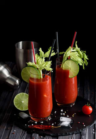 Bloody mary cocktail and ingredients: peper chili, lime, celery, ice and shaker. copy spaceの写真素材