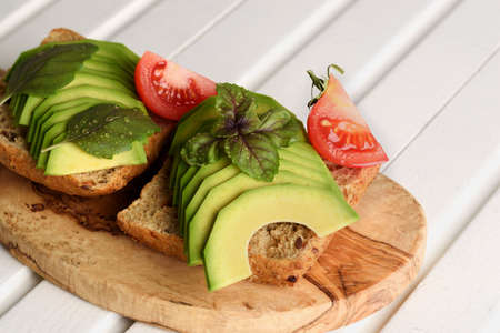 Sandwich with avocado and basil leaves- healthy breakfast conceptの写真素材