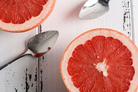 Grapefruit with spoon on white wooden backgroundの写真素材